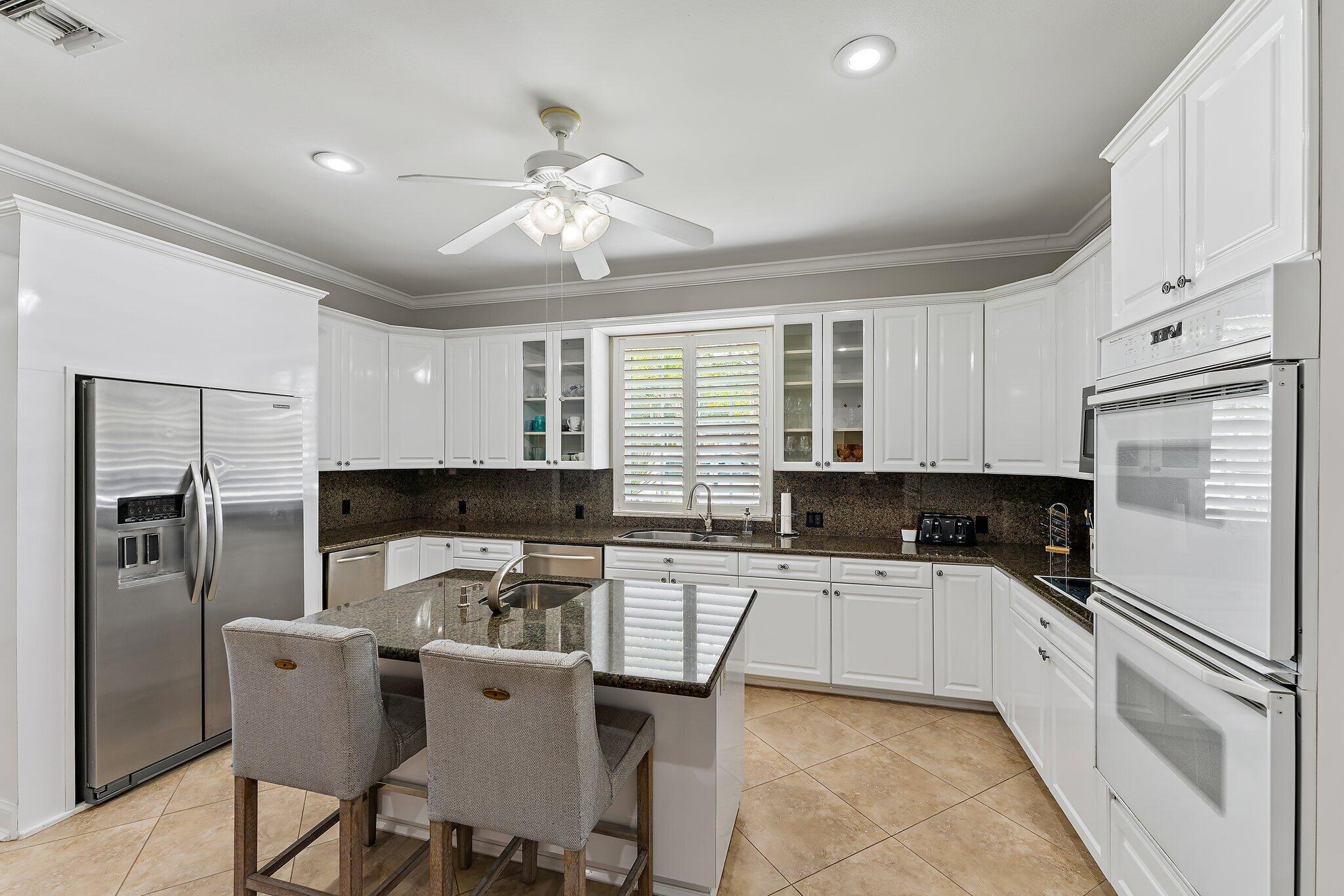 18263 River Oaks Drive Jupiter, FL 33458 - Photo 20 of 49 a kitchen with a refrigerator a sink a stove and cabinets