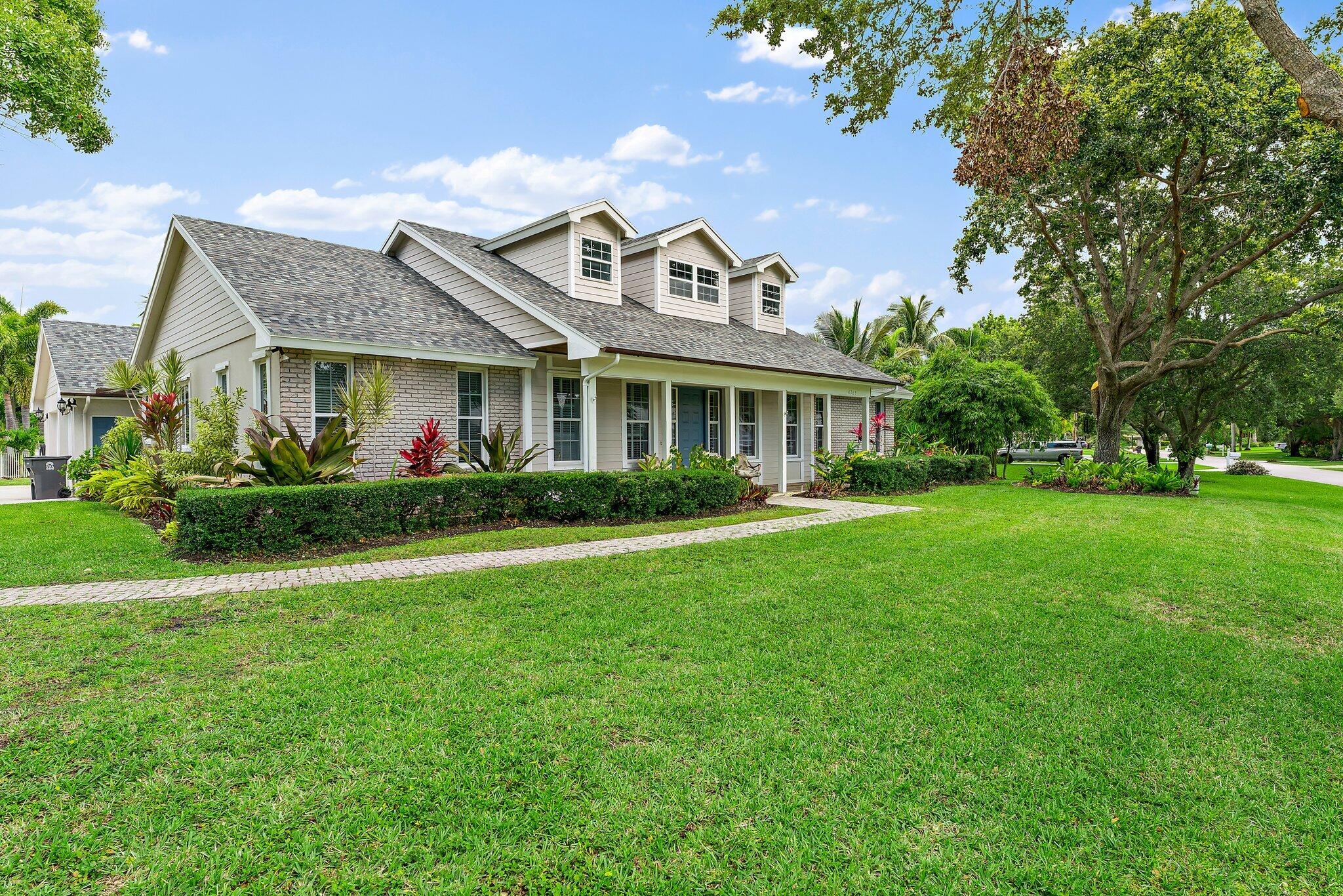 18263 River Oaks Drive Jupiter, FL 33458 - Photo 2 of 49 a front view of house with yard and green space
