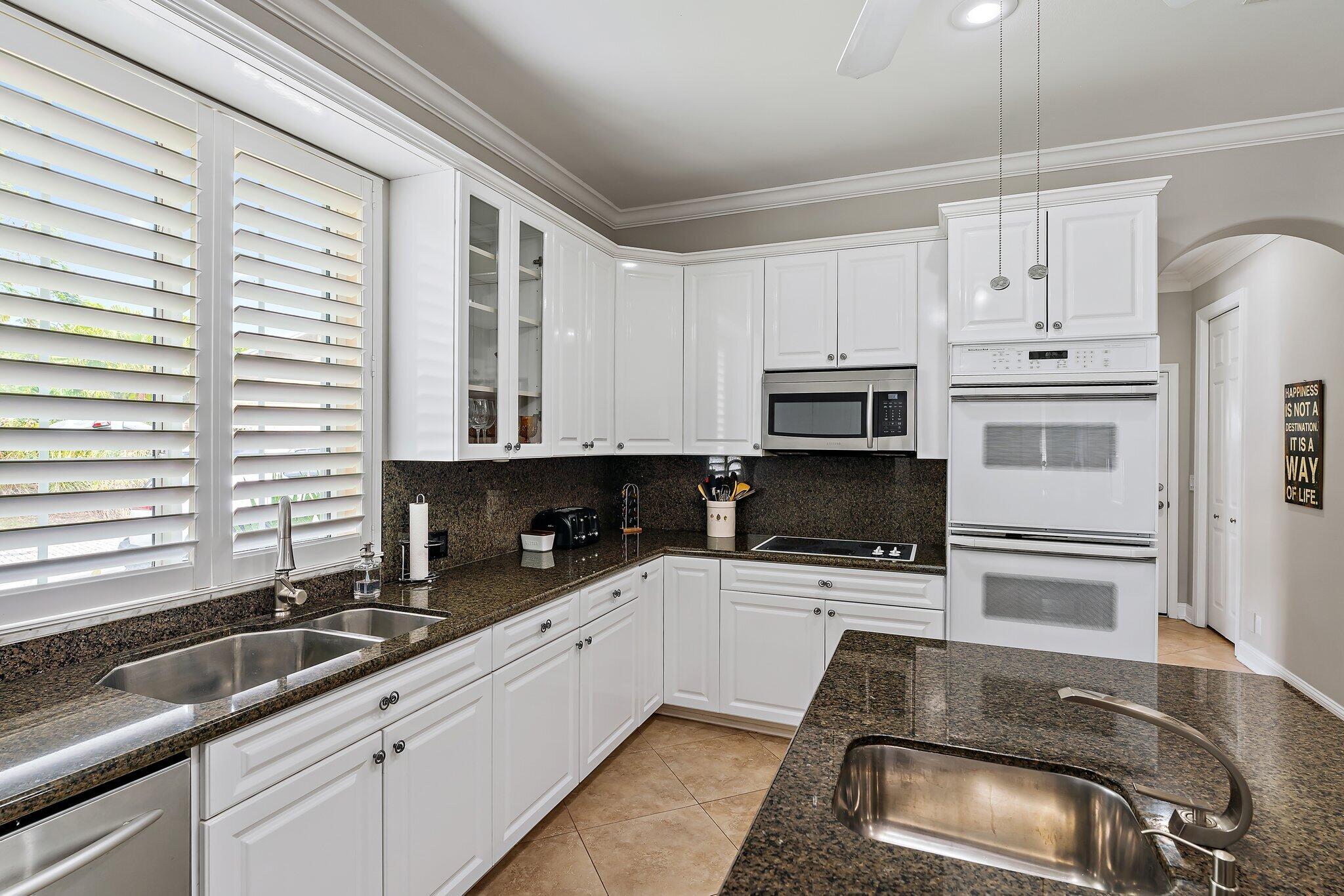 18263 River Oaks Drive Jupiter, FL 33458 - Photo 24 of 49 a kitchen with granite countertop a sink a counter top space cabinets and stainless steel appliances