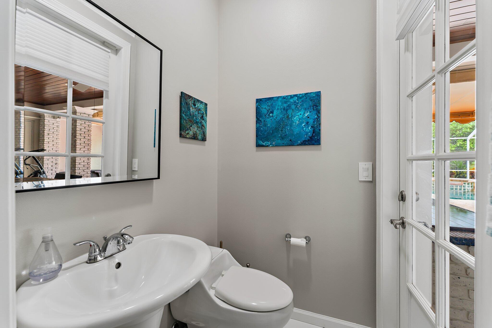 18263 River Oaks Drive Jupiter, FL 33458 - Photo 25 of 49 a bathroom with a toilet a sink and mirror