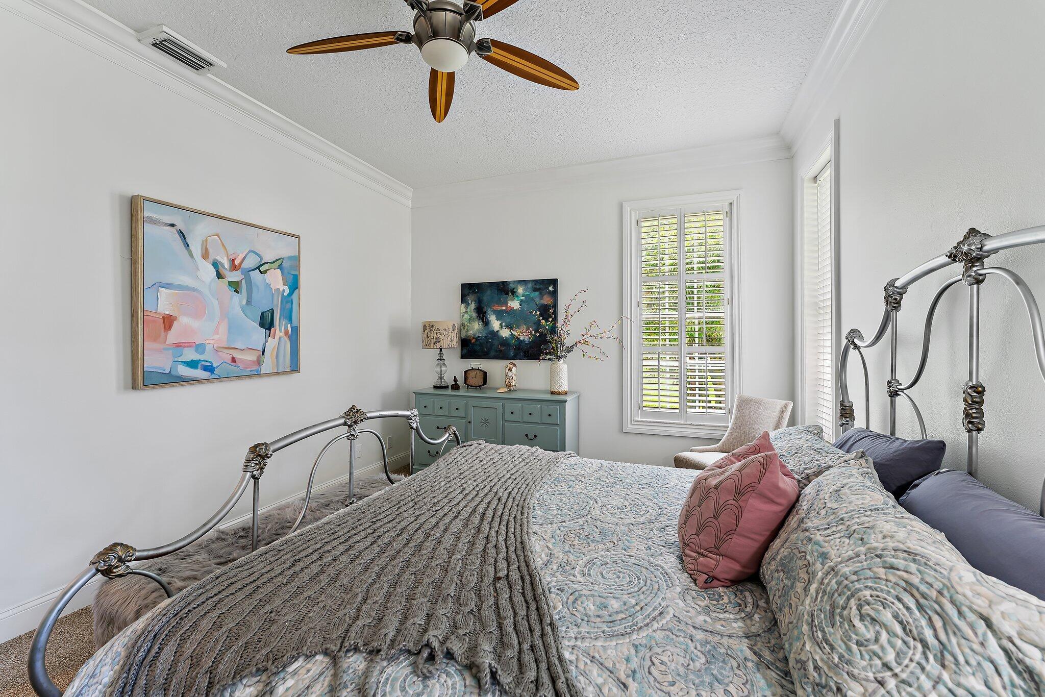 18263 River Oaks Drive Jupiter, FL 33458 - Photo 30 of 49 a bedroom with a bed and a chandelier