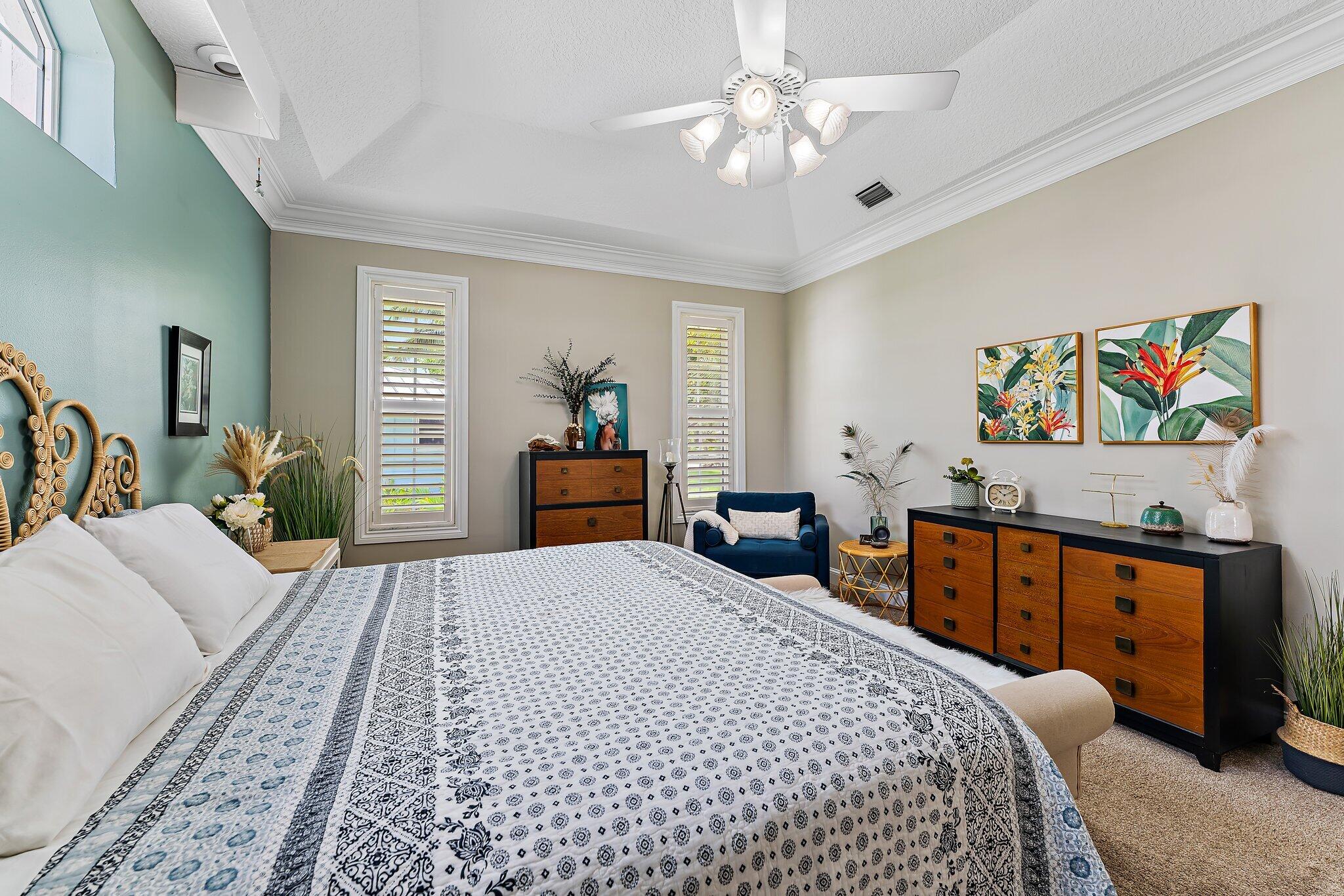 18263 River Oaks Drive Jupiter, FL 33458 - Photo 34 of 49 a bedroom with a bed and a chandelier