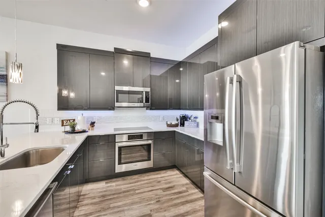 a kitchen with stainless steel appliances kitchen island granite countertop a sink and cabinets