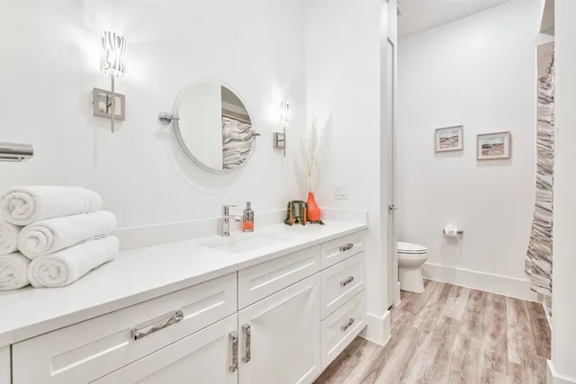 a bedroom with a bed a chandelier and mirror