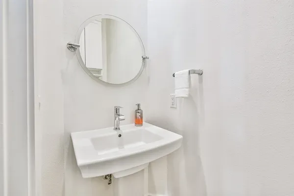 a bathroom with a sink a toilet and a mirror