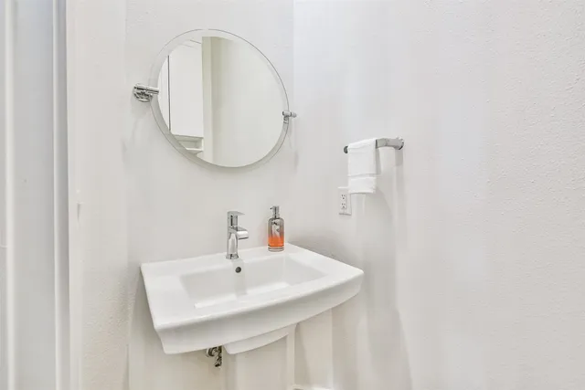 a bathroom with a sink a toilet and a mirror