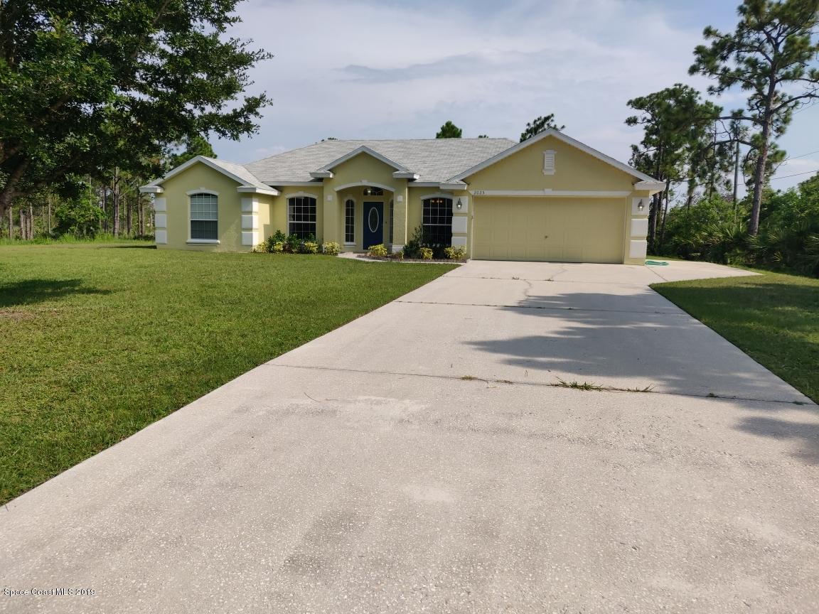 2025 Benjamin Road Grant Valkaria, FL 32950 - Photo 2 of 40 a front view of a house with a yard and garage