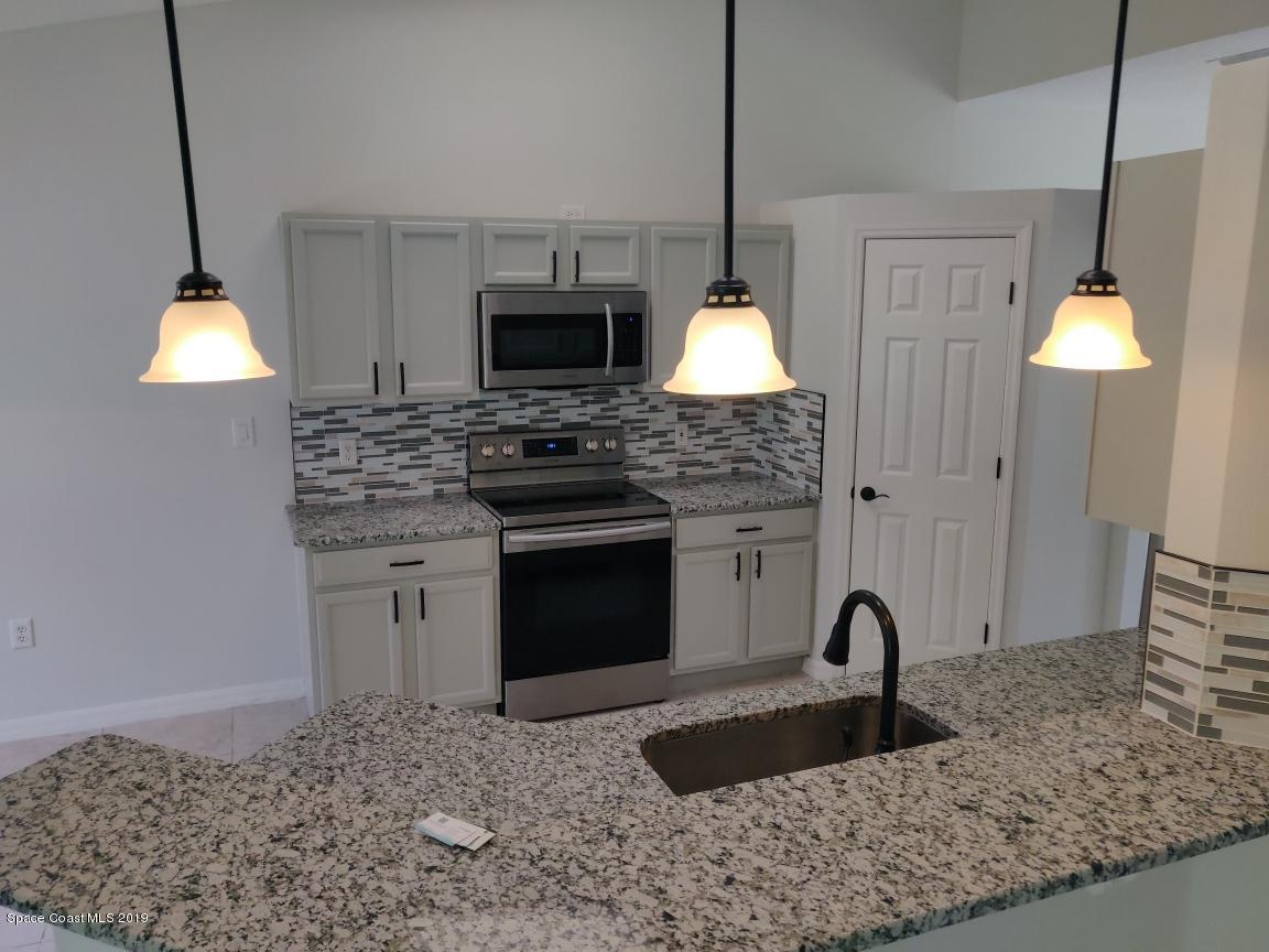 2025 Benjamin Road Grant Valkaria, FL 32950 - Photo 12 of 40 a kitchen with stainless steel appliances granite countertop a sink stove and refrigerator