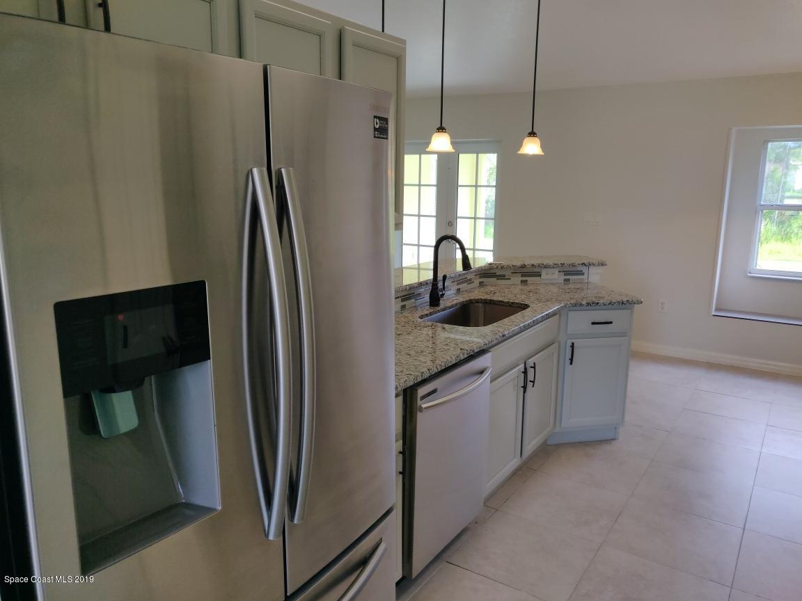 2025 Benjamin Road Grant Valkaria, FL 32950 - Photo 13 of 40 a kitchen with stainless steel appliances granite countertop a refrigerator a sink and a stove
