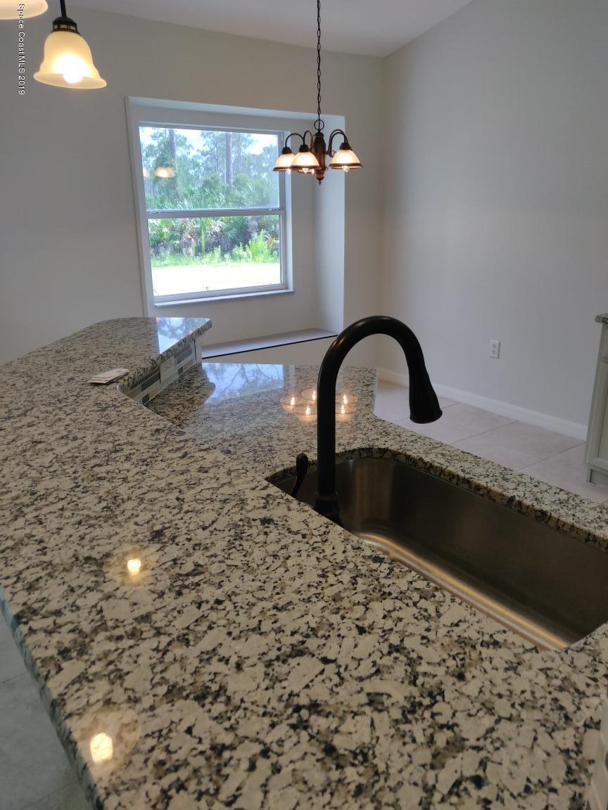 2025 Benjamin Road Grant Valkaria, FL 32950 - Photo 15 of 40 a close view of a faucet a sink and a stove in a room