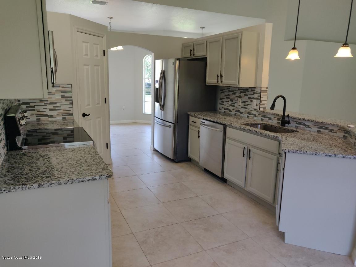 2025 Benjamin Road Grant Valkaria, FL 32950 - Photo 16 of 40 a kitchen with a sink stove and refrigerator