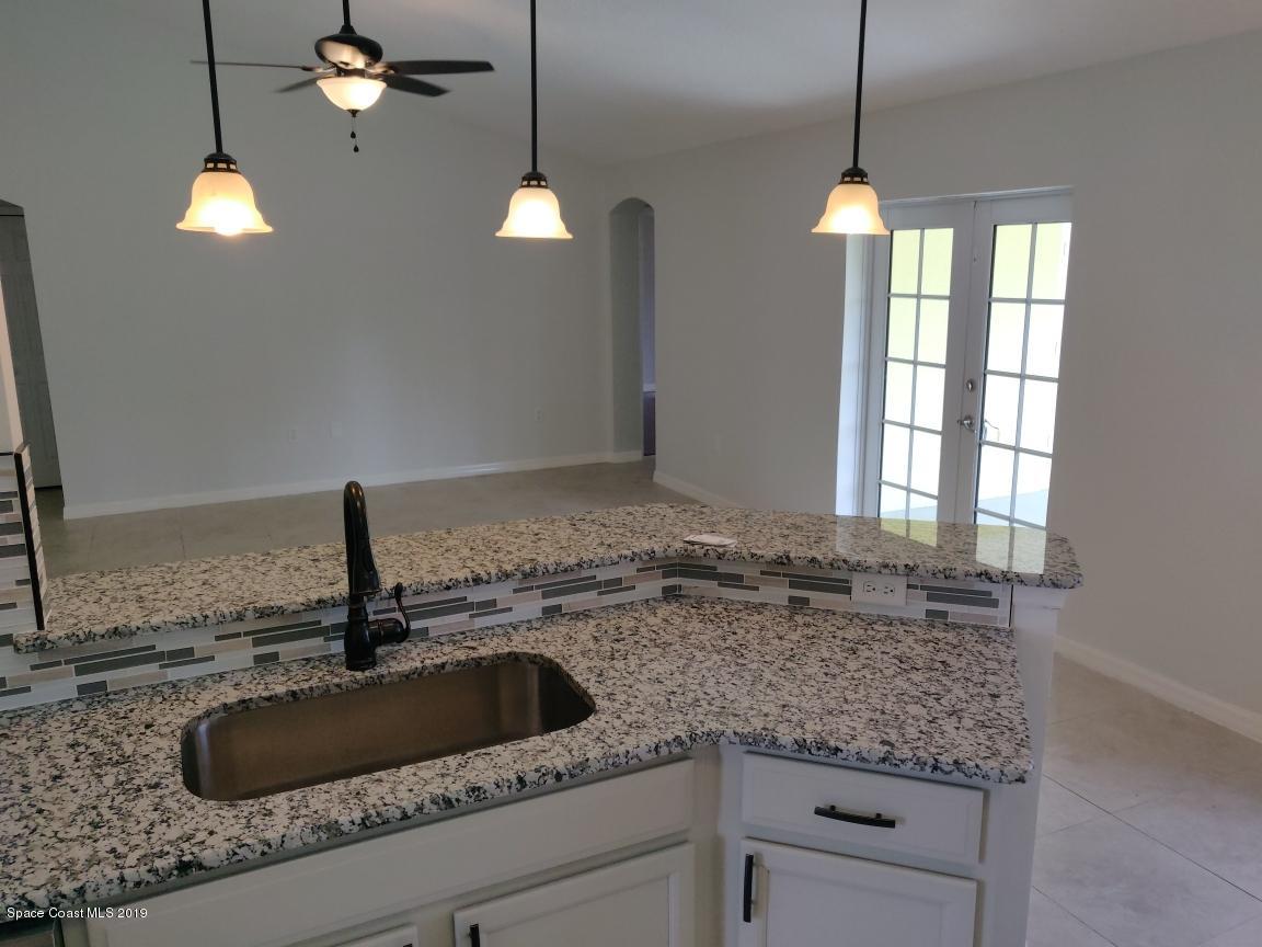 2025 Benjamin Road Grant Valkaria, FL 32950 - Photo 17 of 40 a kitchen with a sink and a granite counter tops