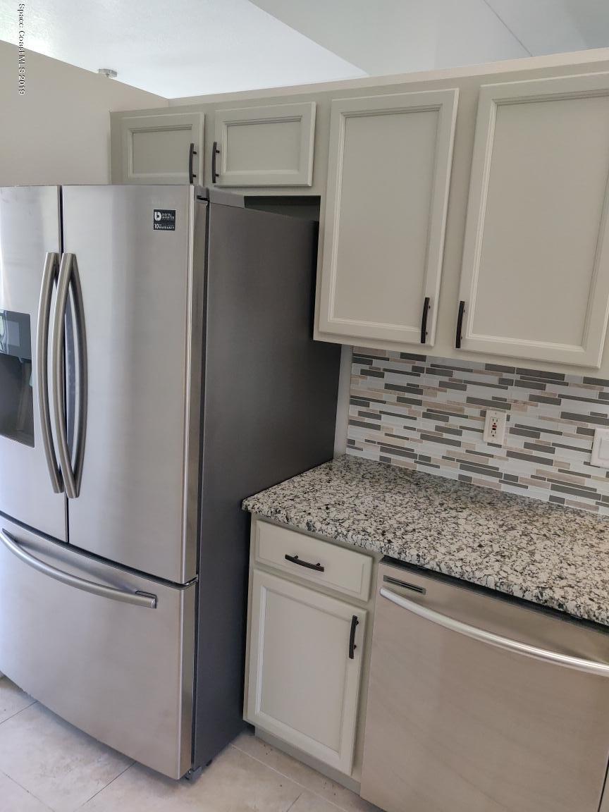 2025 Benjamin Road Grant Valkaria, FL 32950 - Photo 18 of 40 a view of kitchen with refrigerator and white cabinets