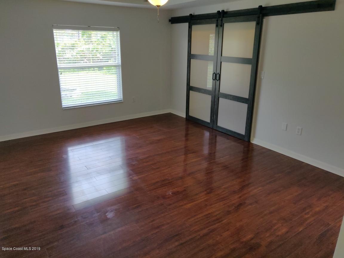 2025 Benjamin Road Grant Valkaria, FL 32950 - Photo 25 of 40 an empty room with wooden floor and windows