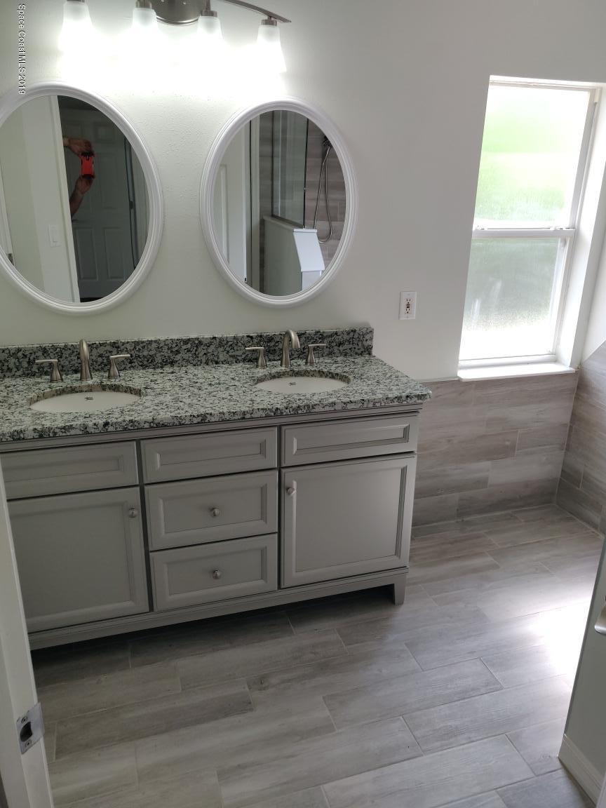 2025 Benjamin Road Grant Valkaria, FL 32950 - Photo 30 of 40 a bathroom with a granite countertop sink and mirror