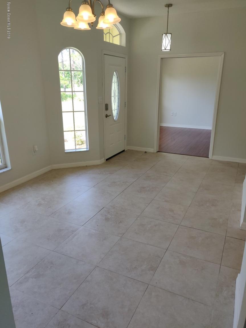 2025 Benjamin Road Grant Valkaria, FL 32950 - Photo 33 of 40 an empty room with windows mirror and brick walls