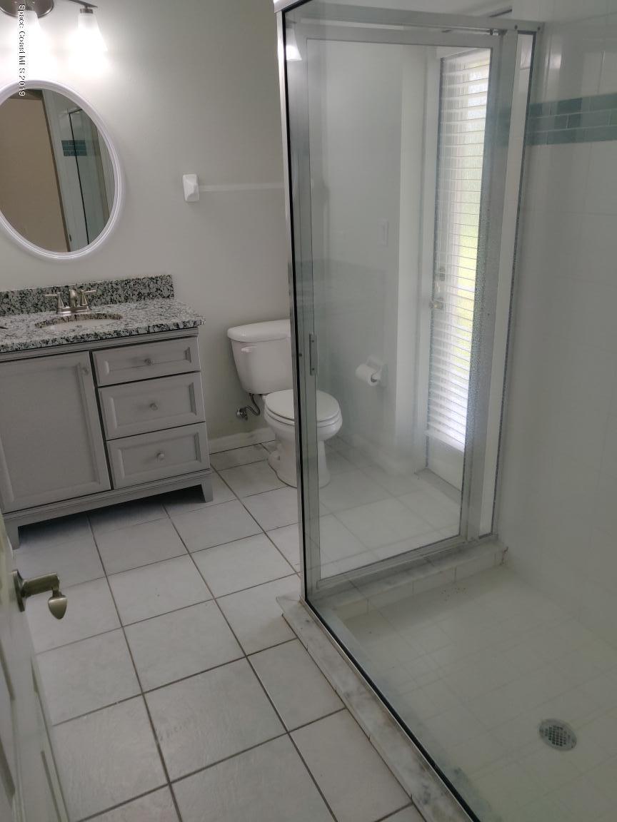 2025 Benjamin Road Grant Valkaria, FL 32950 - Photo 35 of 40 a bathroom with a granite countertop sink a mirror and a shower