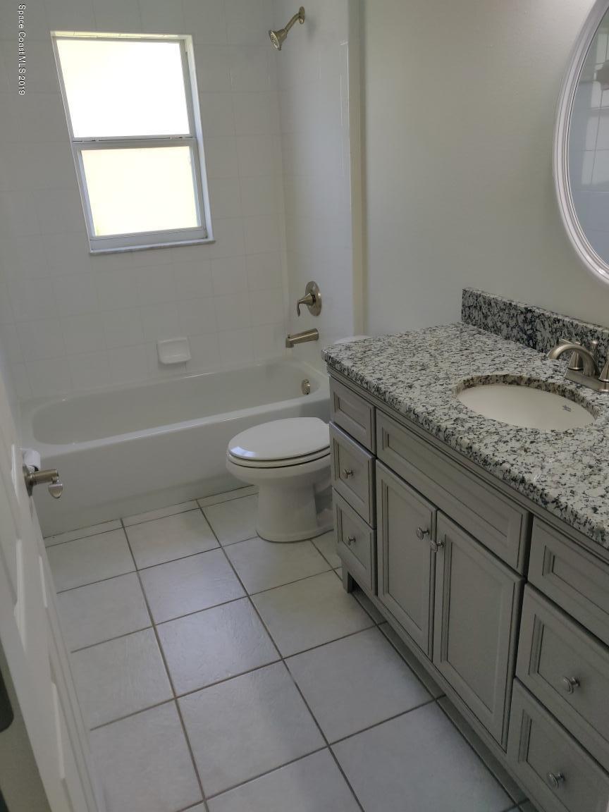 2025 Benjamin Road Grant Valkaria, FL 32950 - Photo 37 of 40 a bathroom with a granite countertop sink a toilet and a mirror