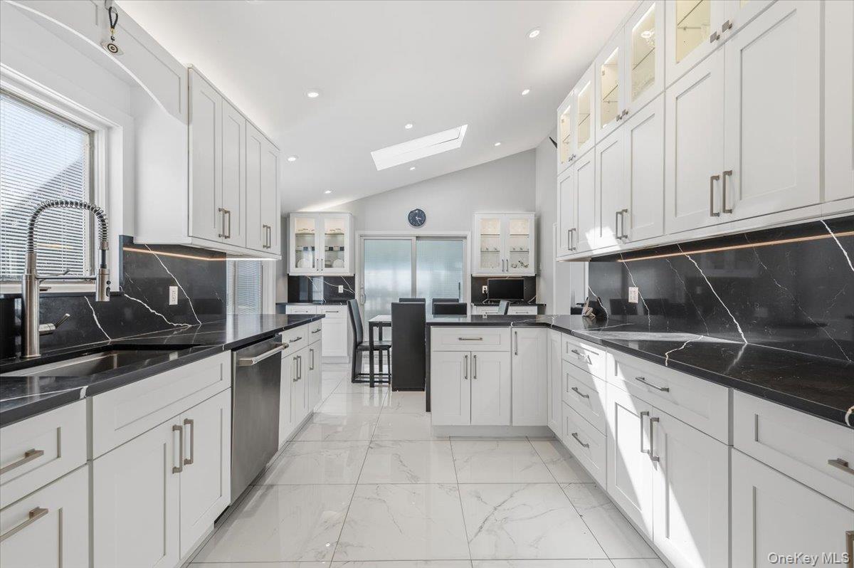 98 Barry Lane Syosset, NY 11791 - Photo 11 of 43 a kitchen with granite countertop a sink stainless steel appliances and white cabinets