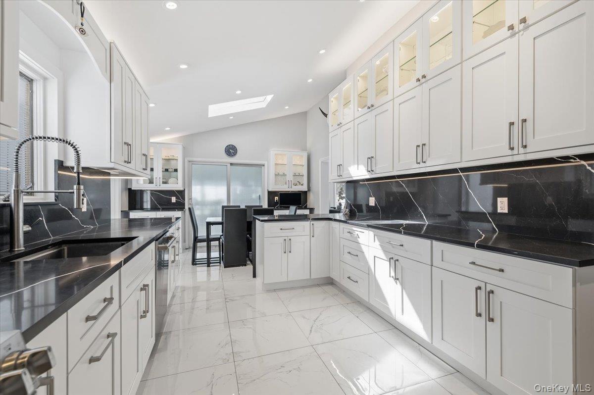 98 Barry Lane Syosset, NY 11791 - Photo 12 of 43 a kitchen with granite countertop white cabinets and stainless steel appliances