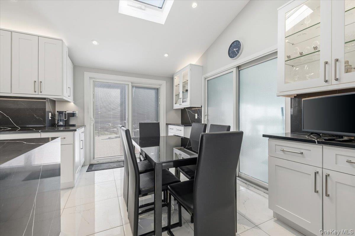 98 Barry Lane Syosset, NY 11791 - Photo 15 of 43 a view of a dining room with furniture and a flat screen tv
