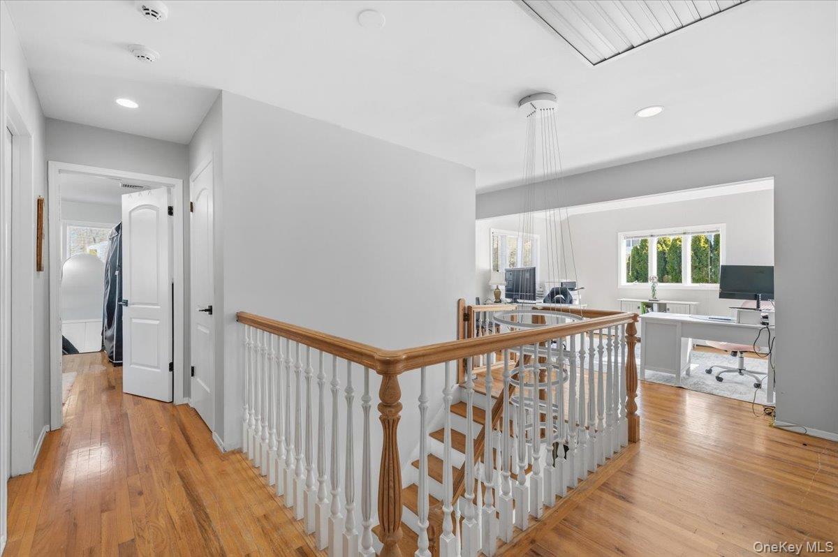 98 Barry Lane Syosset, NY 11791 - Photo 25 of 43 a view of a hallway with wooden floor and windows