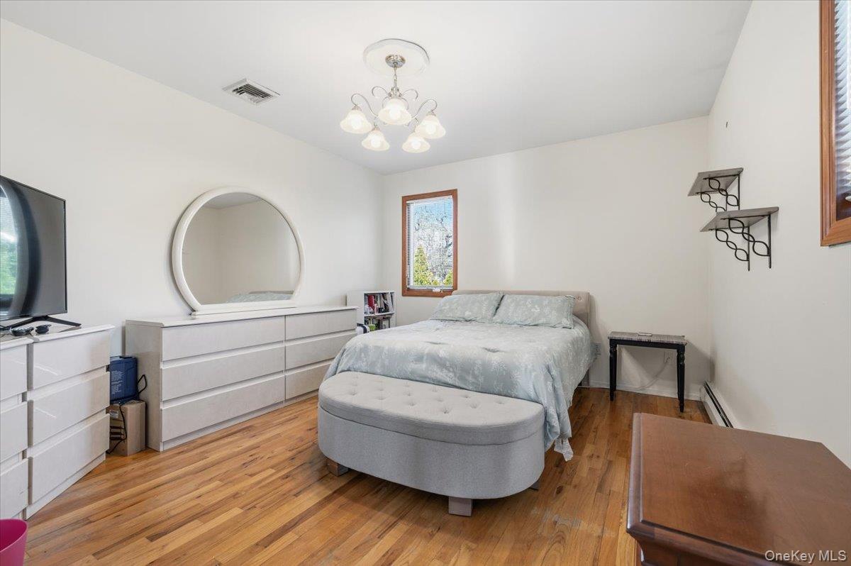 98 Barry Lane Syosset, NY 11791 - Photo 31 of 43 a bedroom with a bed and a dresser