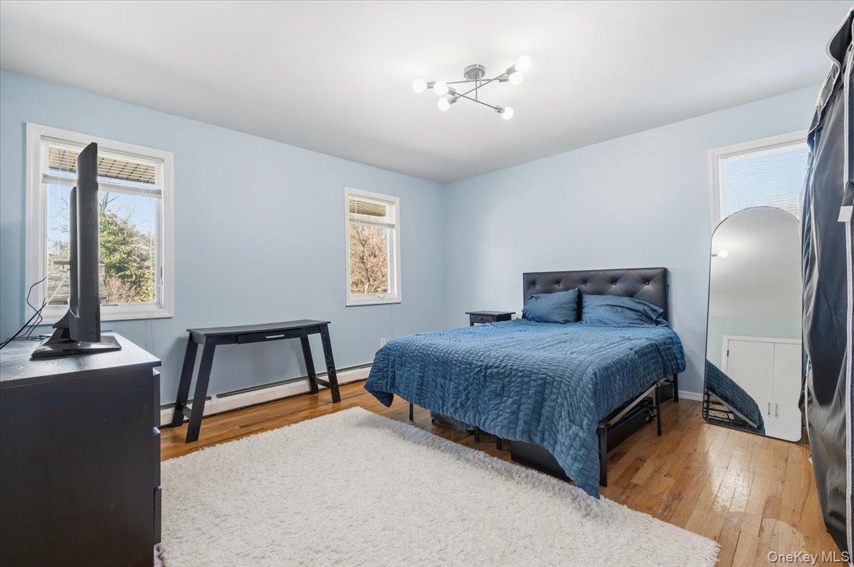 98 Barry Lane Syosset, NY 11791 - Photo 32 of 43 a bedroom with a bed and a chandelier