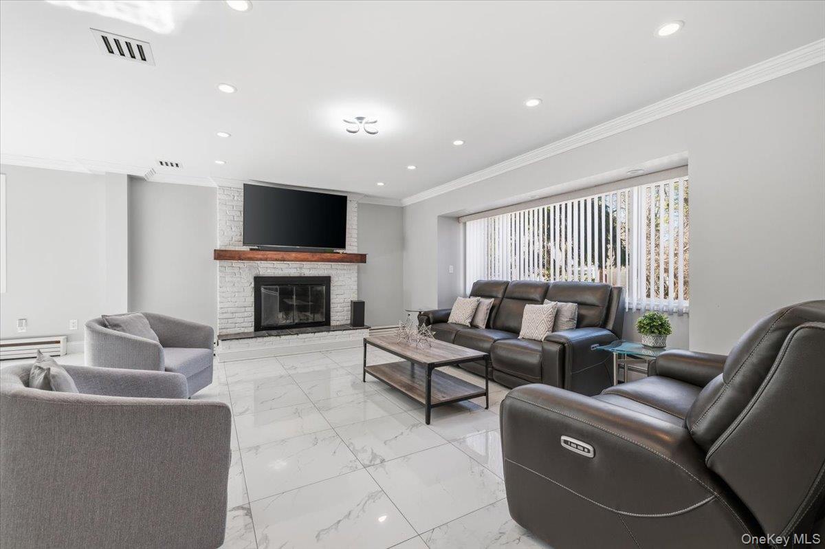 98 Barry Lane Syosset, NY 11791 - Photo 5 of 43 a living room with furniture a flat screen tv and a fireplace
