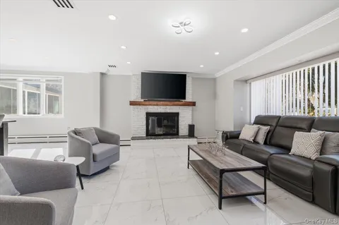 a living room with furniture a flat screen tv and a fireplace
