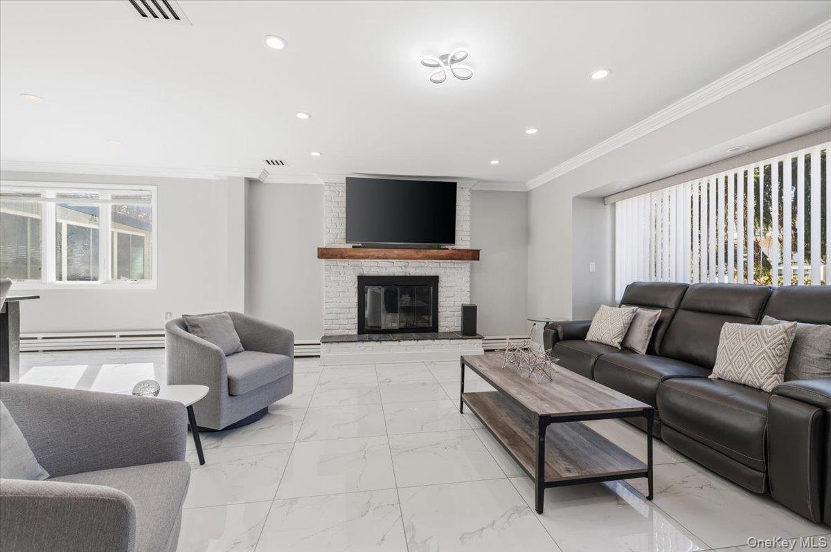 98 Barry Lane Syosset, NY 11791 - Photo 6 of 43 a living room with furniture a flat screen tv and a fireplace