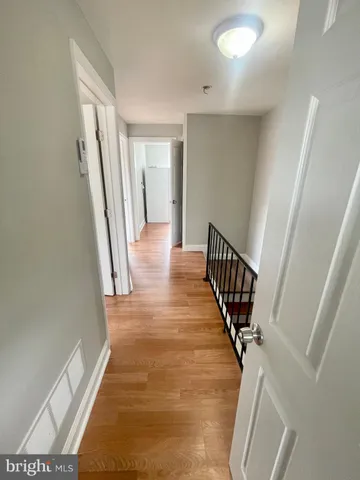 a view of a hallway with wooden floor and stairs