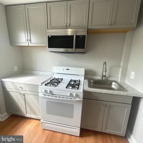 a kitchen with stainless steel appliances granite countertop a sink a stove and a microwave