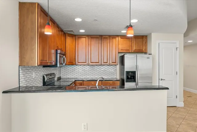 a kitchen with stainless steel appliances granite countertop a sink and a refrigerator