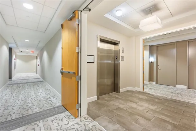 a view of a hallway with wooden floor and living room