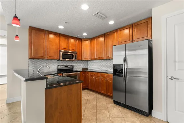 a kitchen with stainless steel appliances granite countertop a refrigerator stove microwave and sink