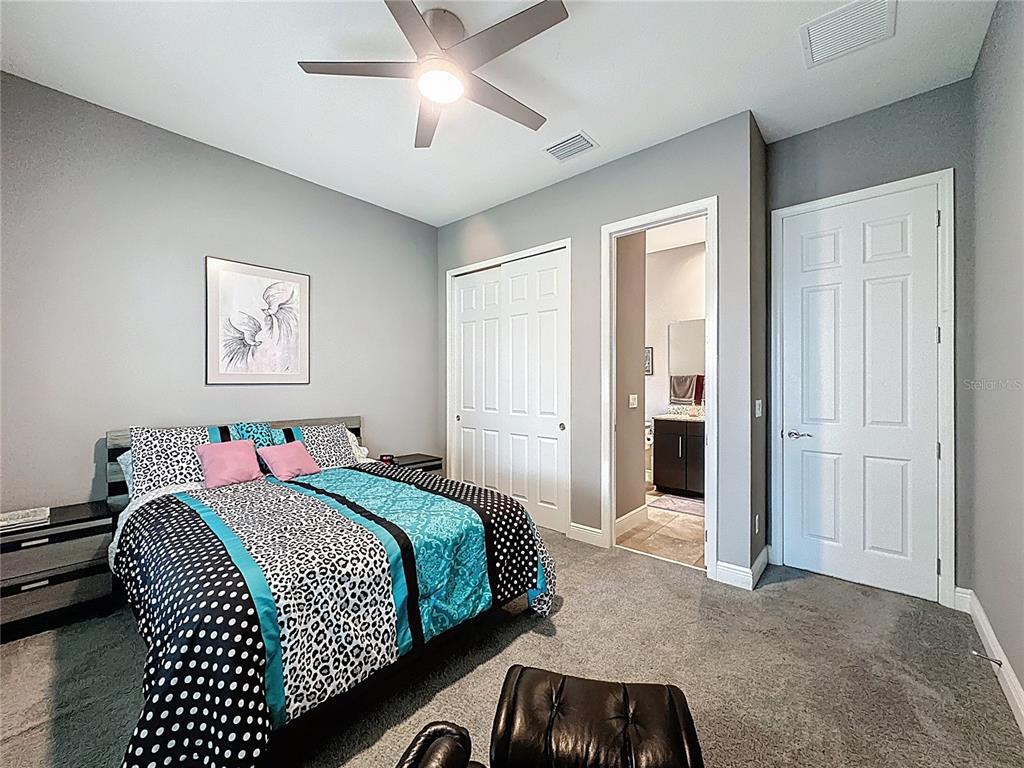 107 Balmy Coast Road Groveland, FL 34736 - Photo 29 of 97 a bedroom with a bed and a chandelier