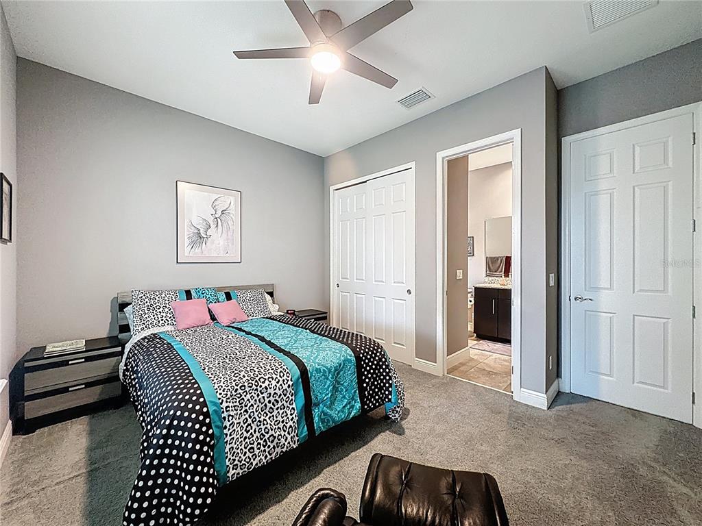 107 Balmy Coast Road Groveland, FL 34736 - Photo 30 of 97 a bedroom with a bed and a chandelier