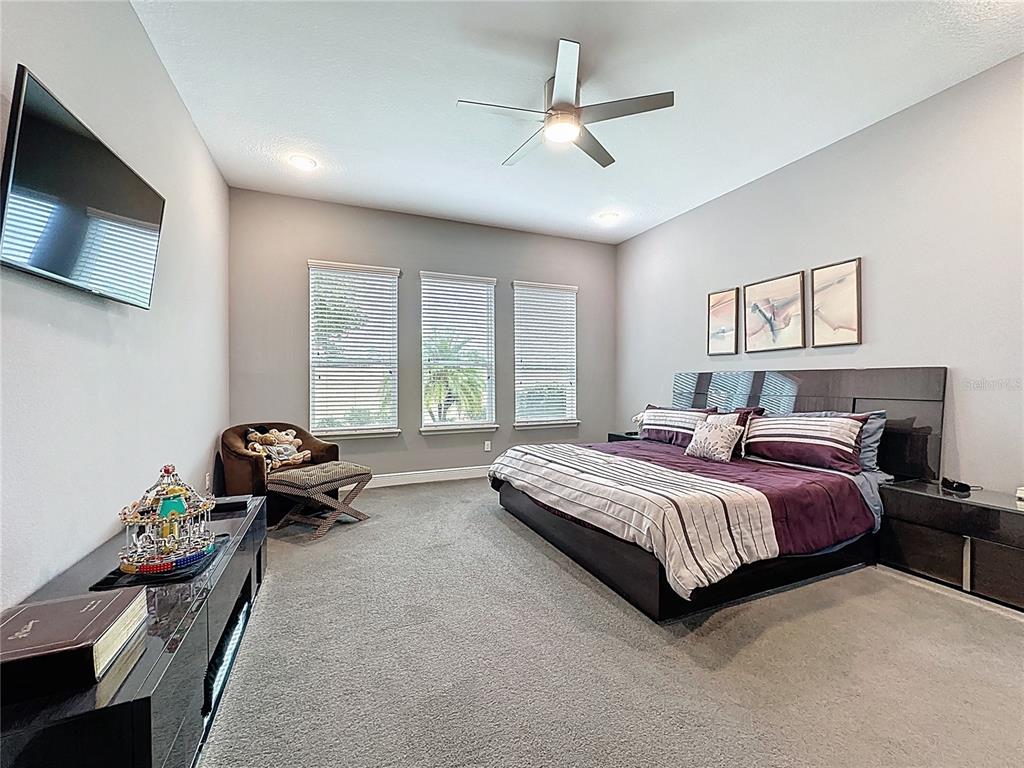 107 Balmy Coast Road Groveland, FL 34736 - Photo 35 of 97 a spacious bedroom with a bed and a flat screen tv