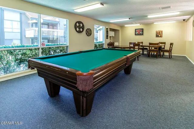 a room with pool table and windows