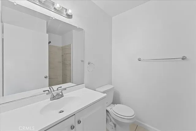 a bathroom with a sink a toilet a mirror and vanity