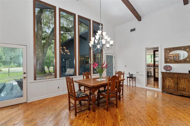 a view of a dining room with furniture wooden floor and chandelier