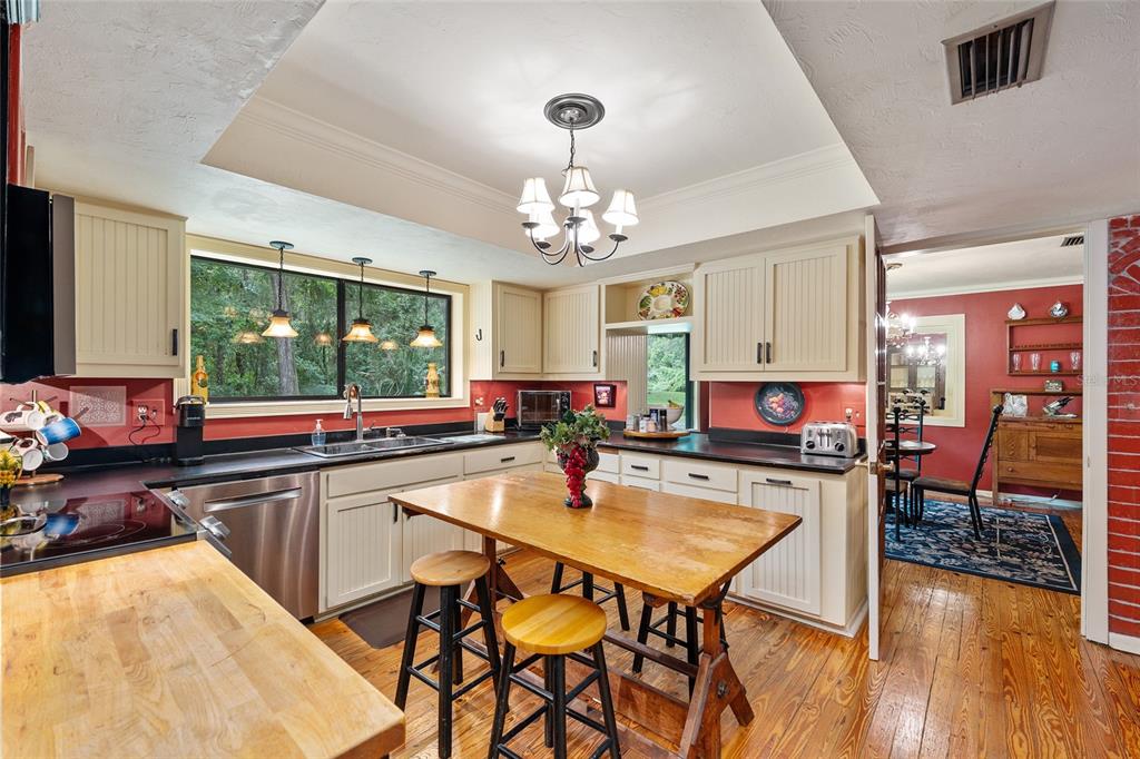 11427 Southwest 10th Terrace Micanopy, FL 32667 - Photo 27 of 77 a view of a dining room with furniture a chandelier and wooden floor