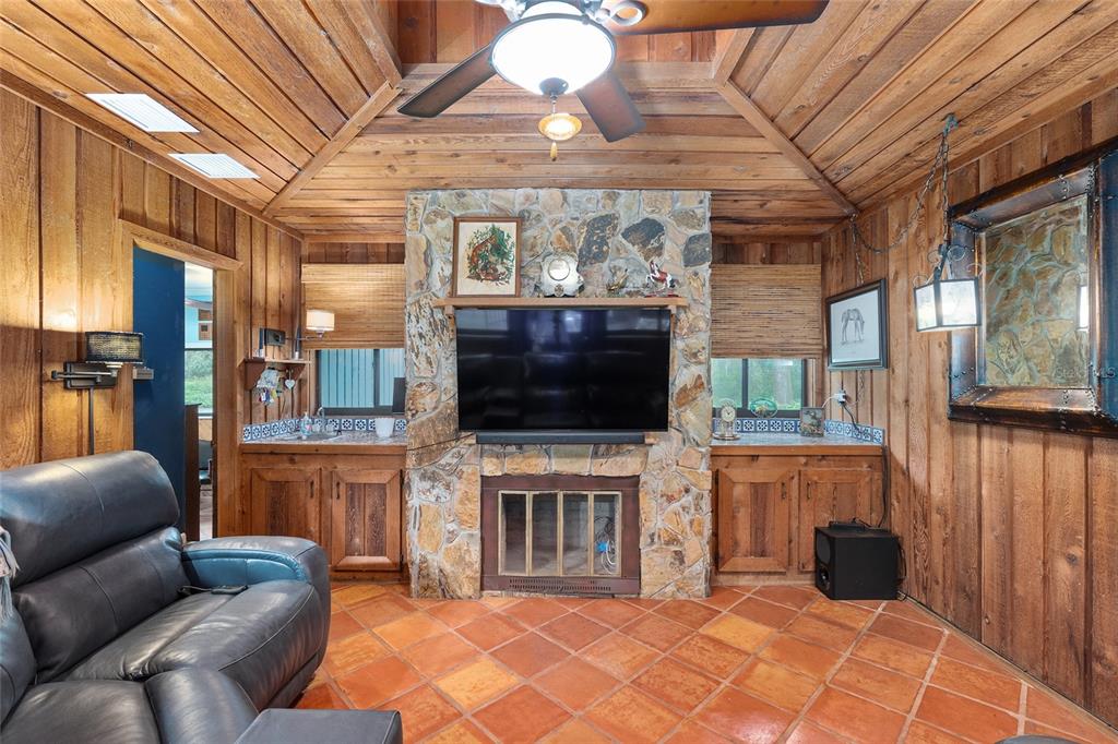 11427 Southwest 10th Terrace Micanopy, FL 32667 - Photo 33 of 77 a living room with furniture a flat screen tv and a fireplace