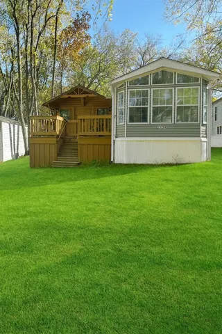 a view of an house with backyard space and balcony