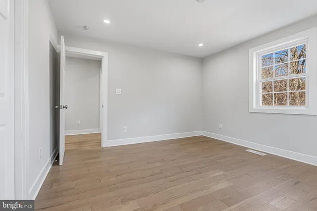 a view of a hallway with wooden floor and entryway