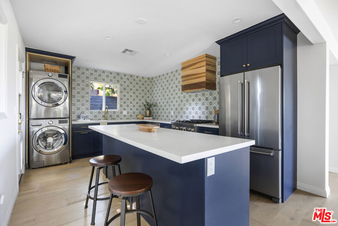 479 Crane Boulevard Los Angeles, CA 90065 - Photo 9 of 35 a kitchen with stainless steel appliances granite countertop a sink a stove a refrigerator and a refrigerator with wooden floor