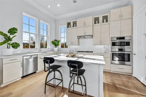a kitchen with a sink stove and white cabinets
