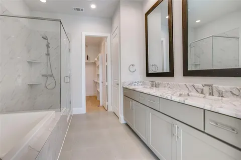 a bathroom with a granite countertop sink mirror and a bathtub