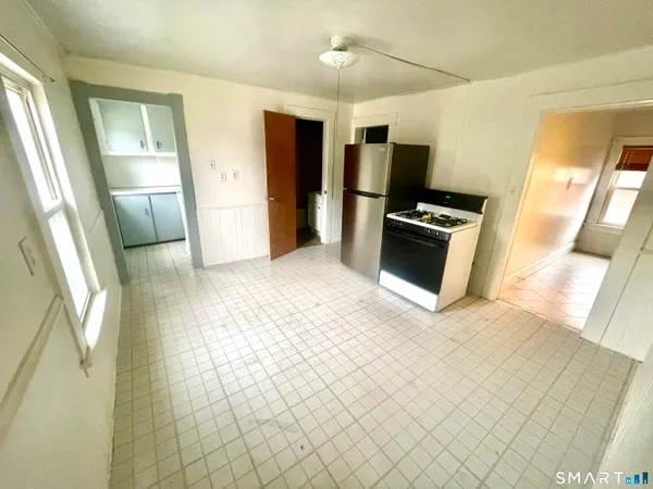 a view of a refrigerator in kitchen and a window